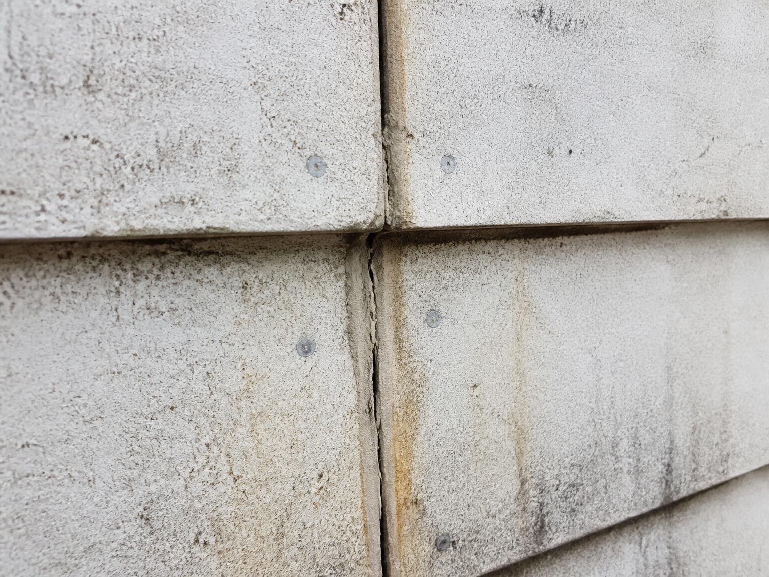 Weathered asbestos cladding panels requiring professional assessment