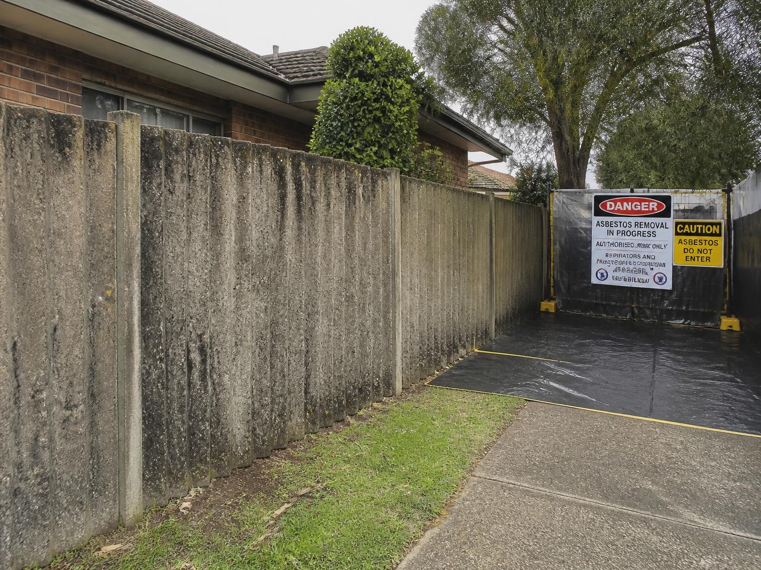 Asbestos cement fence panels awaiting professional removal