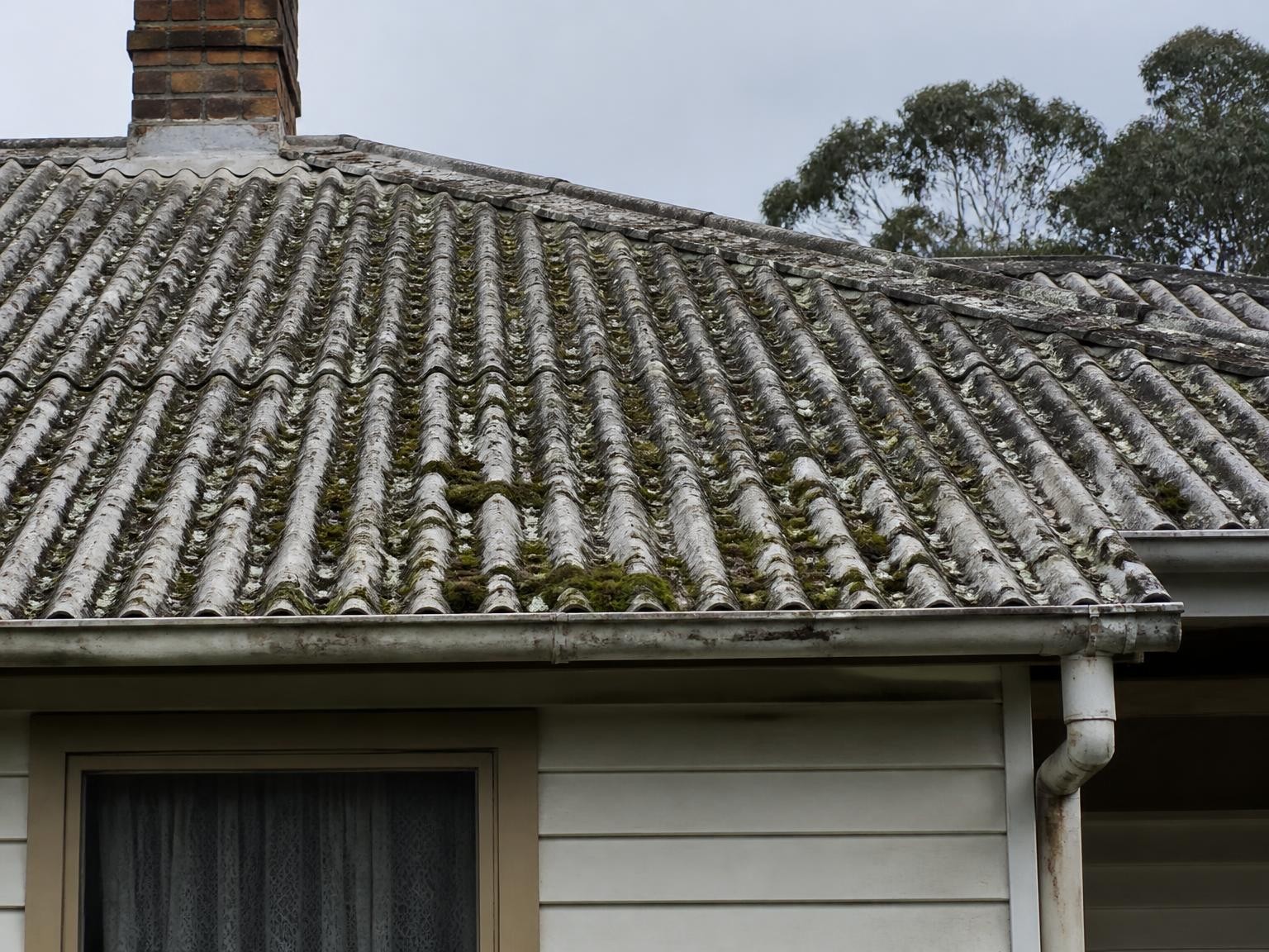 Weathered asbestos cement roof sheets on an older property