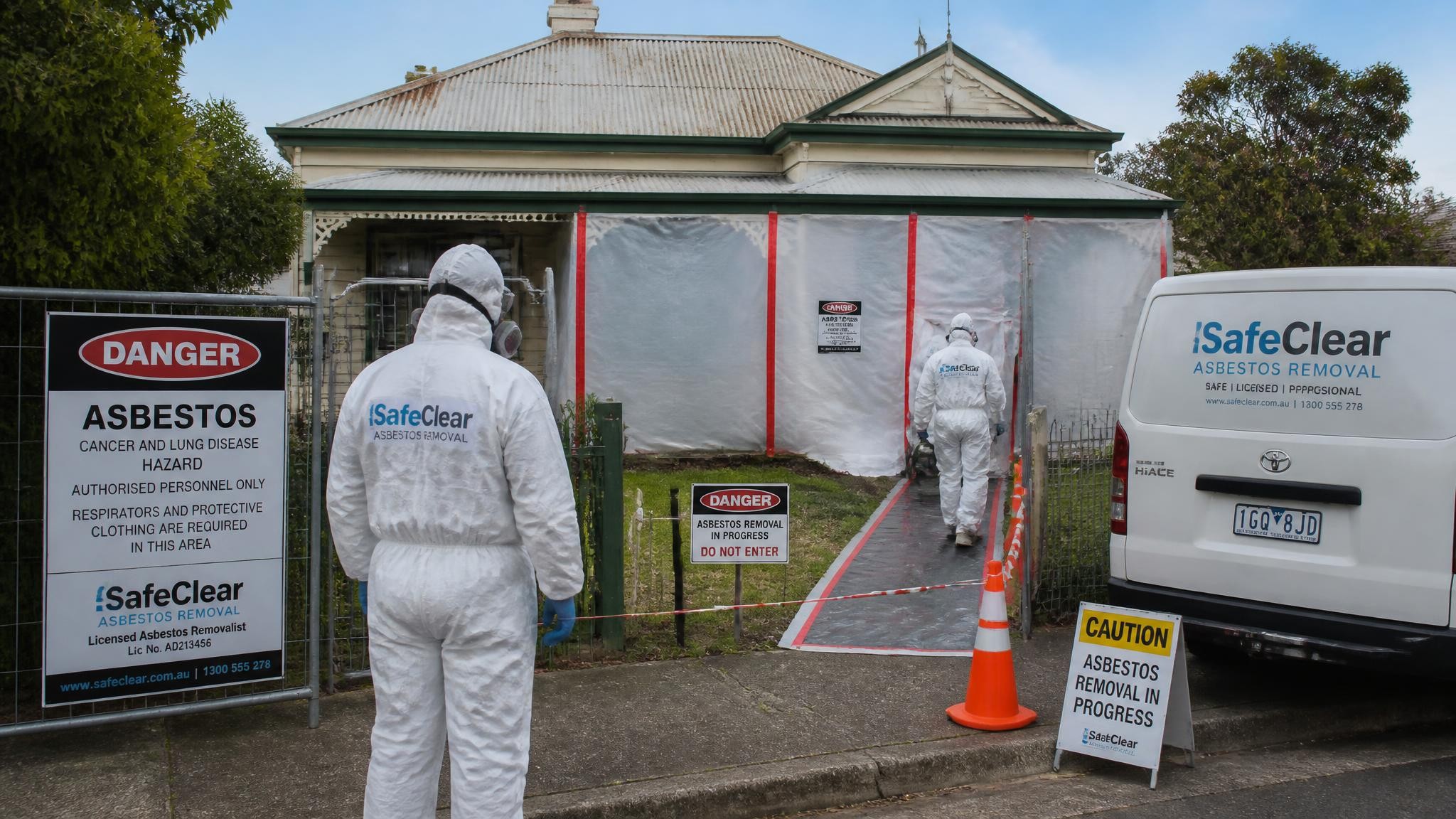 Licensed asbestos abatement team preparing a controlled work area